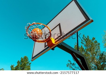 Street basketball ball falling into the hoop. Urban youth game. Concept of success, scoring points and winning.