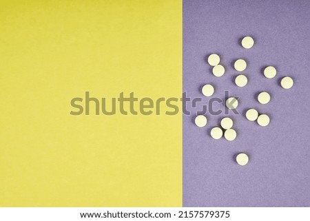 Yellow pills on colorful background