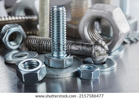 set of different nuts, bolts, screws, washers and drill bits,thread tap and mill cutters on steel plate background. Locksmithing deal. Royalty-Free Stock Photo #2157586477