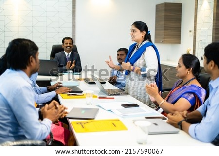 woman employee speaking confidently at board meeting in front of cowrkers - concept of briefing strategy, business planning and leadership Royalty-Free Stock Photo #2157590067