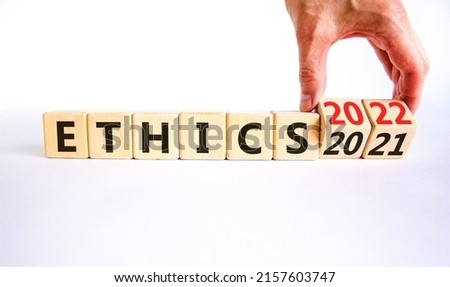 2022 ethics and new year symbol. Businessman turns wooden cubes and changes words 'ethics 2021' to 'ethics 2022'. Beautiful white background, copy space. Business, 2022 ethics and new year concept.