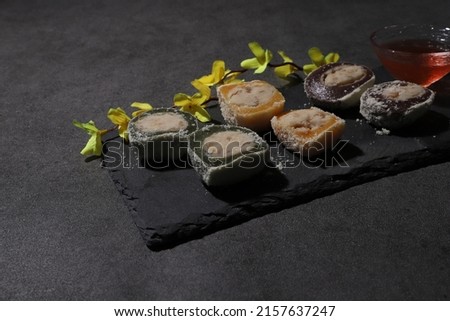 Teok, Korean traditional snack, rice cake,  jeolpyeon, mochi, rice snack, colorful rice snack with black background and drink and chopsticks Royalty-Free Stock Photo #2157637247