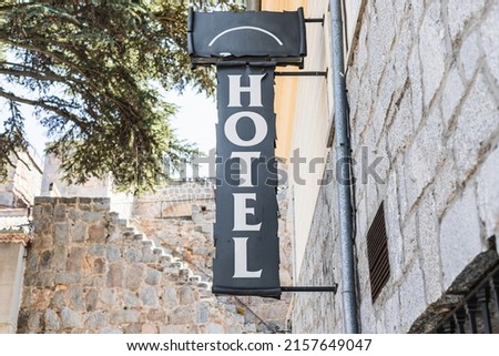 hotel sign, medieval place, medieval walls in the background, medieval arch