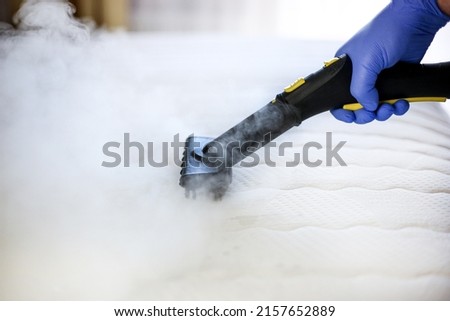 Cleaning and disinfection of the mattress in the bedroom with hot steam. Professional cleaning process Royalty-Free Stock Photo #2157652889