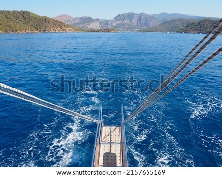 Göcek, seen behind the tour boat sailing to the sea. Muğla, Turkey Royalty-Free Stock Photo #2157655169