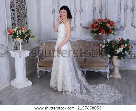 Beautiful long legged brunette girl in wedding dress and white stockings posing in studio Beautiful long legs, pretty face,hot pose 