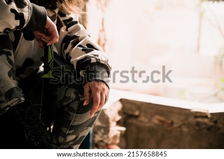 a closeup shot of girl sitting on table in military outfit