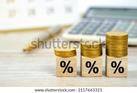 Percentage sign on wooden cubes with coins on top. on the desk business background. Financial.                         