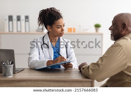 Healthcare, Geriatric Medicine, Medical Check Up. Senior man visiting doctor tell about health complaints, female gp writing personal information, filling form attentively listening to elderly patient Royalty-Free Stock Photo #2157666083