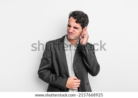 young businessman feeling stressed, frustrated and tired, rubbing painful neck, with a worried, troubled look
