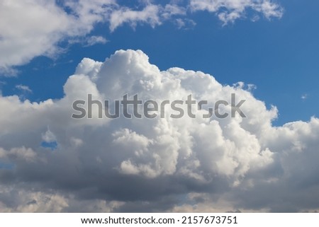 Huge fluffy white cumulus cloud against a bright blue sky Royalty-Free Stock Photo #2157673751