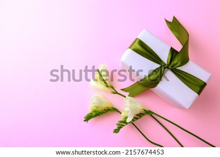 Gift box and spring flowers on pink background. Stylish soft image of spring flowers. Happy womens day. Happy Mothers day.Hello Spring