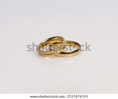Jewelery ring with diamonds. Wedding rings that have deep meaning and significance. Engagement ring with gemstones. Wedding ring isolated on white background, focus blur. Pair in gold, silver, black.
