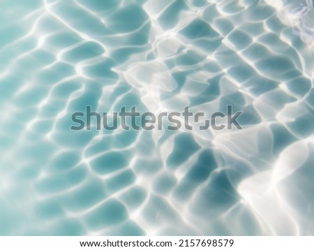 Closeup​ blur​ abstract​ of​ surface​ blue​ water.Abstract​ of​ surface​ blue​ water​ reflected​ with​ sunlight​ for​ background.Top​ view​ of blue​ water.​ Water​ splashed​ use​ for​ graphic​ design.