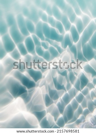 Closeup​ blur​ abstract​ of​ surface​ blue​ water.Abstract​ of​ surface​ blue​ water​ reflected​ with​ sunlight​ for​ background.Top​ view​ of blue​ water.​ Water​ splashed​ use​ for​ graphic​ design.