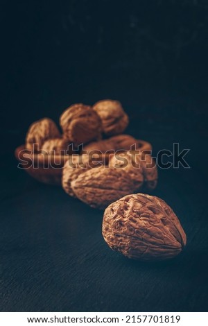 Walnuts on a dark background. The concept of proper nutrition. Walnuts are an excellent source of antioxidants and including LDL cholesterol, which prevention atherosclerosis. 