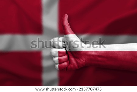 Hand making thumb up painted with flag of denmark