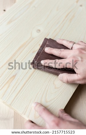 Sanding boards by hand. Sanding with abrasive paper. Royalty-Free Stock Photo #2157715523