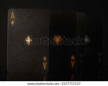 Black poker cards with gold embossing. Isolated on black background. Close-up. Gambling, poker, game strategy, casino, night club, gambling business.