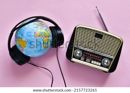 Retro radio, headphones and globe on pink background. World radio day. world music day. Top view, flat lay, top view