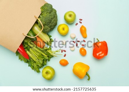 Paper bag with healthy products on white background