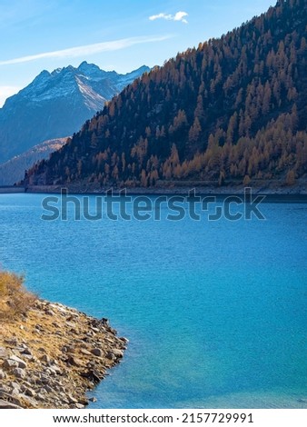 Blue river and mountains view, in sunny autumn day, Alps, Italy