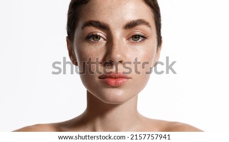 Skin care. Beauty woman with freckles, thick eyebrows and pink lips, has clear perfect skin, face with natural glow after cosmetic cream, spa effect, white background Royalty-Free Stock Photo #2157757941