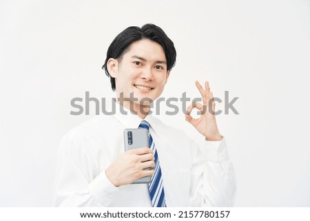 Asian businessman OK gesture with the smartphone in white background
