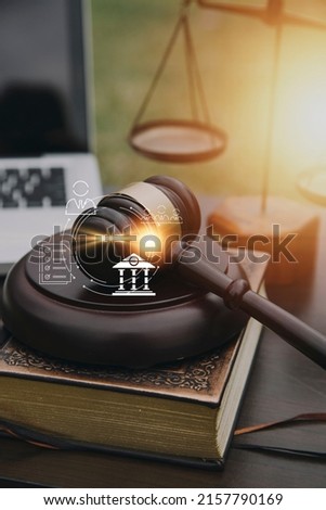 Justice and law concept.Male judge in a courtroom with the gavel, working with, computer and docking keyboard, eyeglasses, on table in morning light