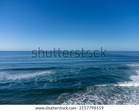 Aerial view of the ocean shot at the shoreline with waves breaking. Great copy space. 