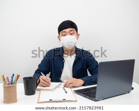 Sickman wearing mask sitting at workplace white background