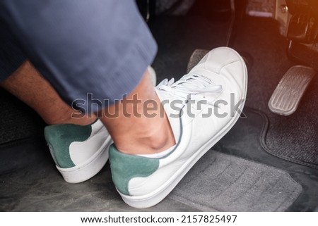 Man foot pressing accelerator and breaking pedal in a car Royalty-Free Stock Photo #2157825497