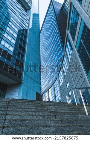Modern building with glass facades reflecting parts of the building and wide staircase, vertical