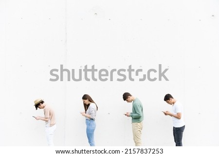 Queue of teenagers using their phones in bad posture. Lordosis and kyphosis on young people concept. Royalty-Free Stock Photo #2157837253