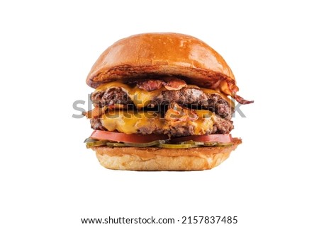 Delicious double burger with beef, bacon, cucumbers and tomatoes. isolated