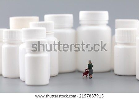 Miniature creative lonely old man facing medicine bottle