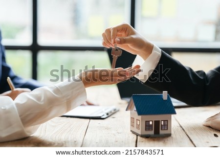 The real estate agent is explaining the house style to the clients who come to contact to see the house design and the purchase agreement.
