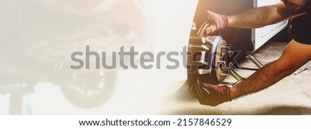 Car mechanic hand checking disc brakes and caliper of car and automobile repairing double exposure blurred on white background with panoramic copy space