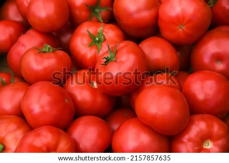
Tomatoes lying on a pile on top of each other, tomato texture. Selective focus.