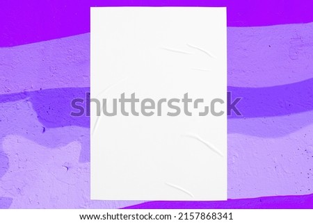 Closeup of colorful purple, violet, lilac painted urban wall texture with wrinkled glued poster template. Modern mockup for design presentation. Creative urban city background. 