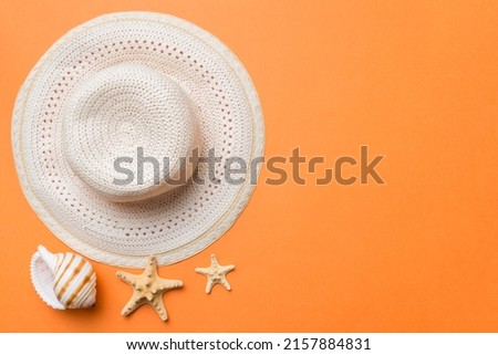 Summer holidays. Summer concept with straw hat and tropical leaf. Flat lay, top view, copy space.