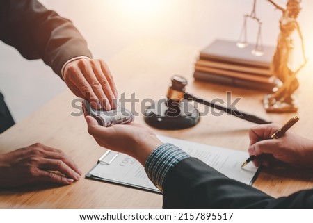 Concepts of corruption, bankruptcy courts, bail, crime, bribery, fraud, Judge Gavel, soundboard, and a handful of cash on the table. Royalty-Free Stock Photo #2157895517