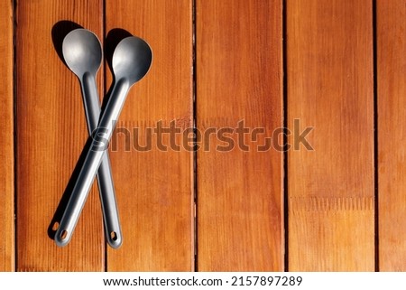 Titanium camp spoons on a wooden table. High quality photo