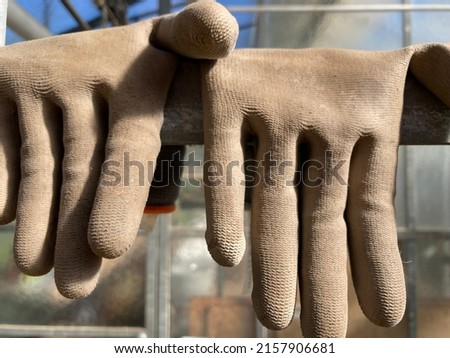 used gloves hang down over an edge