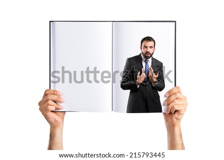 Young businessman surprised printed on book