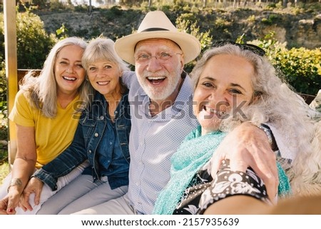 Excited senior friends taking a selfie together during vacation. Cheerful elderly people enjoying a weekend getaway at a spa resort. Group of happy senior citizens having fun after retirement. Royalty-Free Stock Photo #2157935639