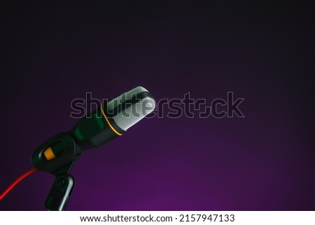 Stand with microphone on dark color background, closeup
