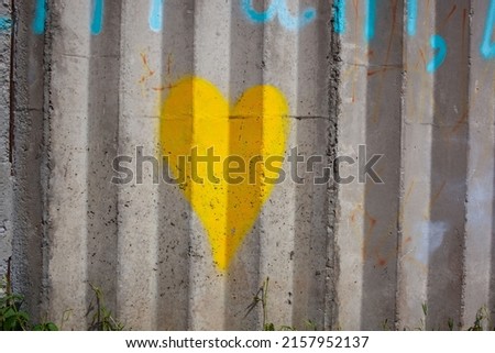 yellow color heart drawing on a concrete wall