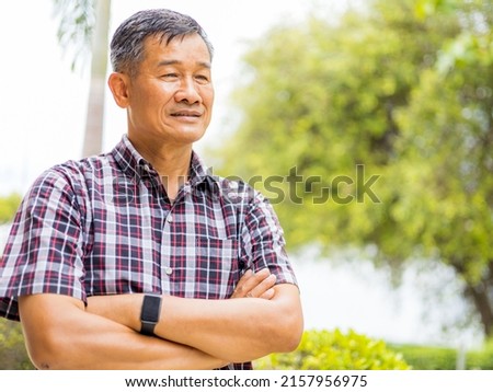 Portrait close-up shot of middle-aged Asian male model with short black hair wearing a plaid shirt with stand smiling at home