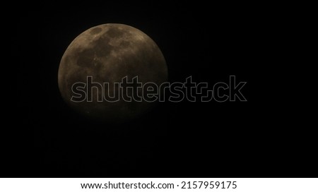 full moon behind the cloud on the black night sky